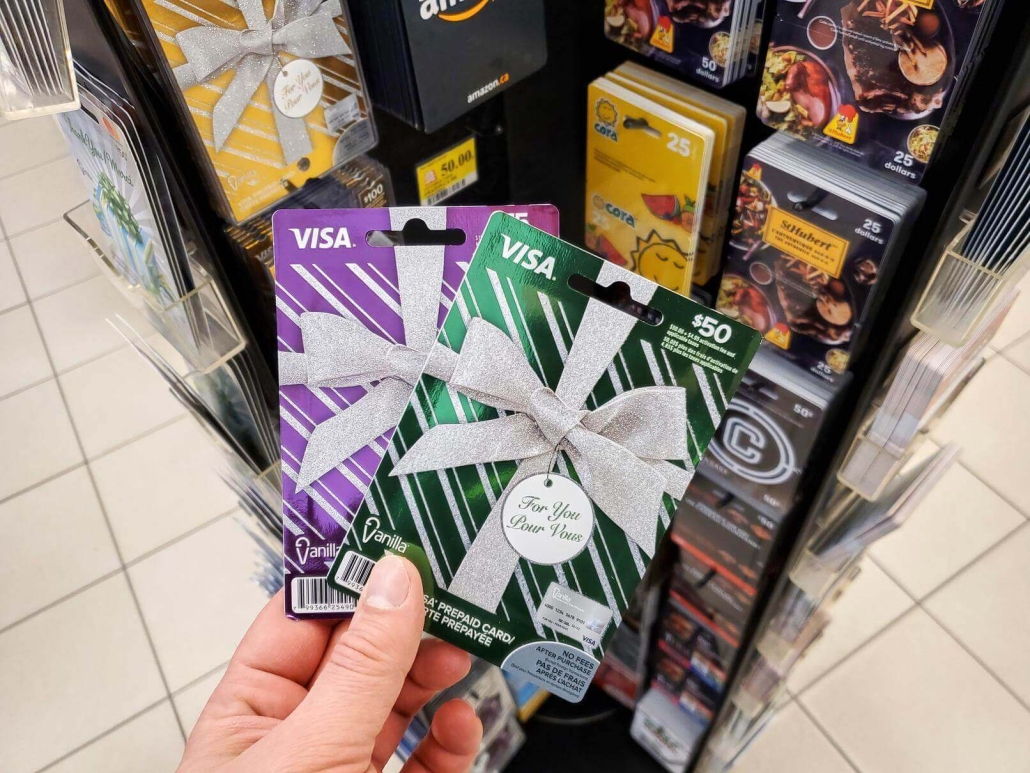 Подарочная карта Visa в руке на фоне подарочных карт.